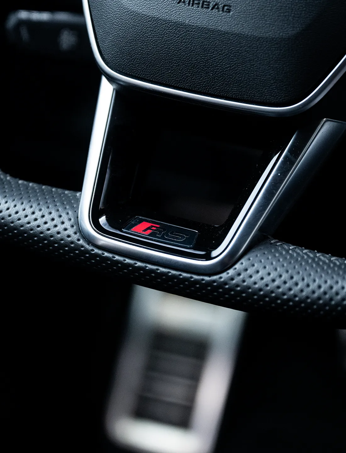Detal kierownicy w ciemnym wnętrzu Audi RS