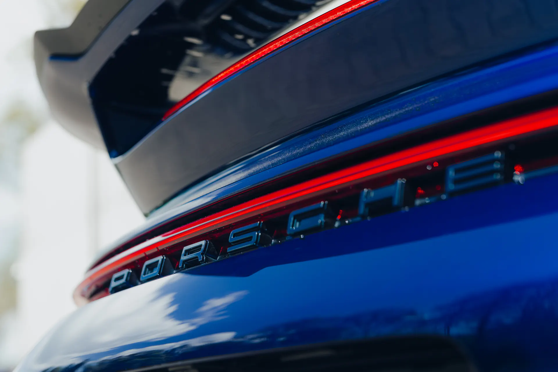 Tył niebieskiego Porsche 911 z podświetlonym pasem i oznaczeniem modelu